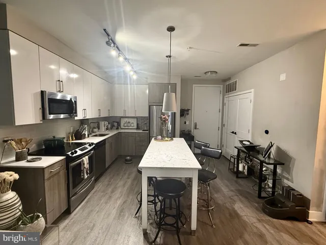 a kitchen with stainless steel appliances granite countertop a sink refrigerator stove and microwave