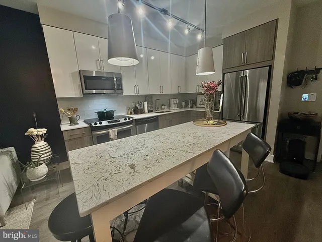 a kitchen with stainless steel appliances granite countertop a sink refrigerator stove and microwave