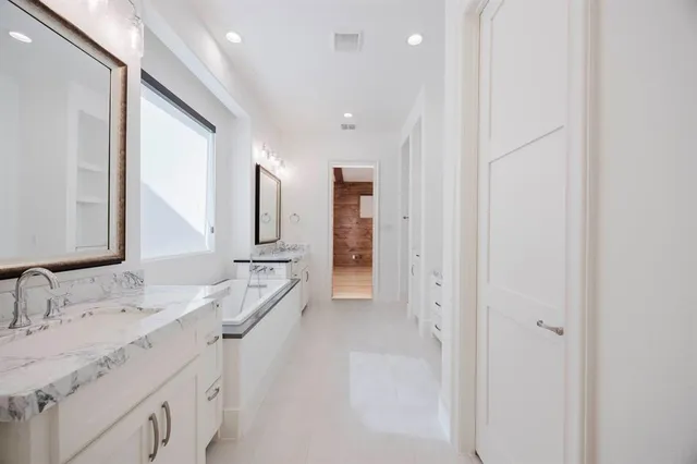 a spacious bathroom with a double vanity sink and mirror
