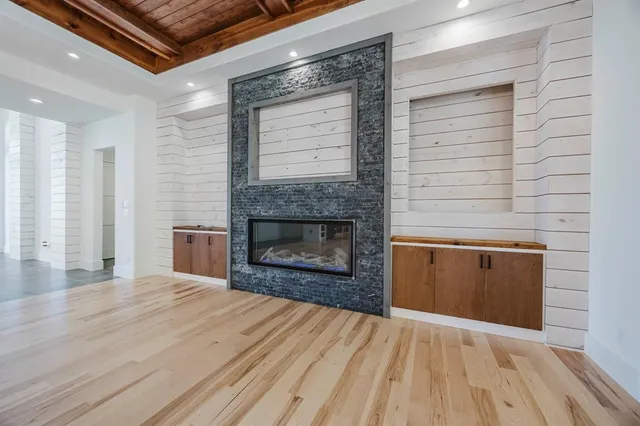 an empty room with wooden floor and fireplace
