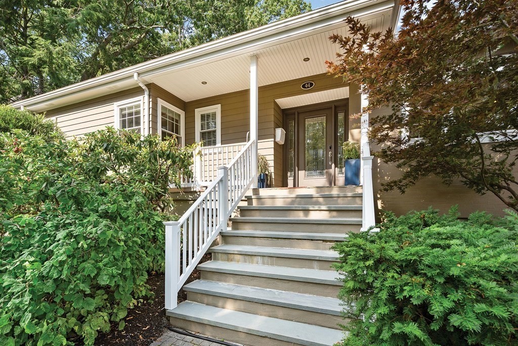 44 Rolling Lane Newton, MA 02467 - Photo 1 of 18 a view of a house with a large windows and flower plants