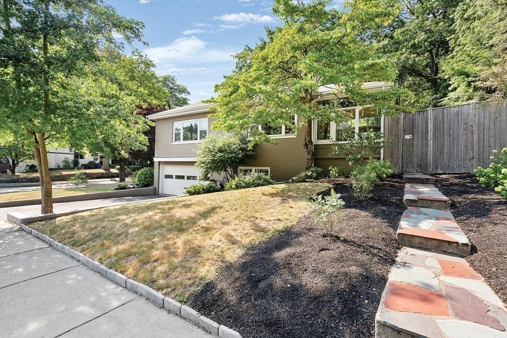 44 Rolling Lane Newton, MA 02467 - Photo 2 of 18 a view of a backyard with a garden and trees