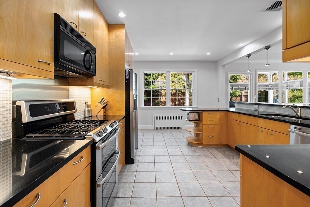 44 Rolling Lane Newton, MA 02467 - Photo 8 of 18 a kitchen with stainless steel appliances granite countertop a stove a sink and a microwave