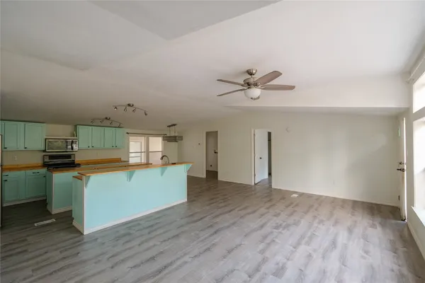 a kitchen with stainless steel appliances a stove top oven a sink with wooden floor and cabinets
