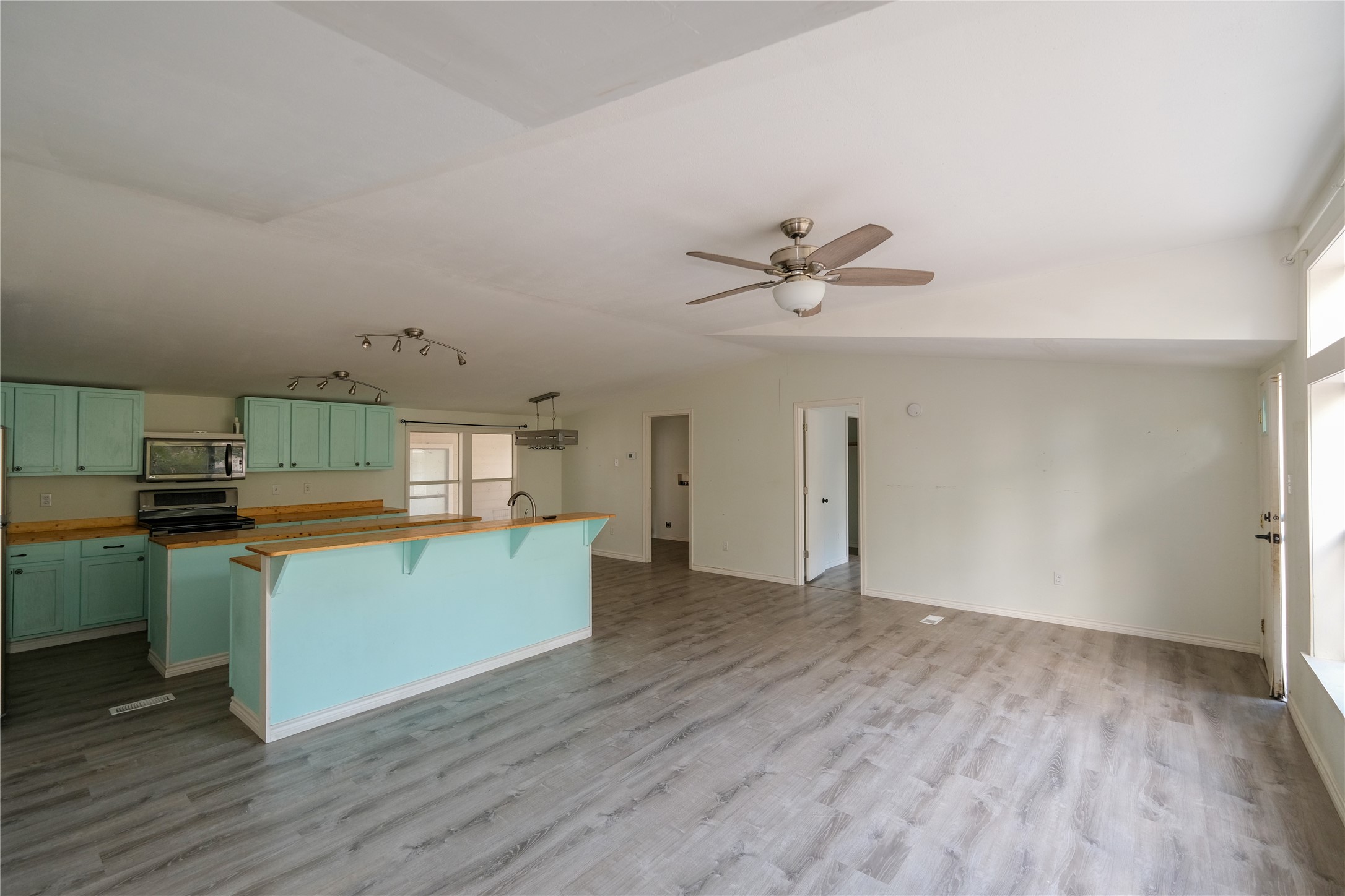 170 W Creek Trinity, TX 75862 - Photo 12 of 47 a kitchen with stainless steel appliances a stove top oven a sink with wooden floor and cabinets
