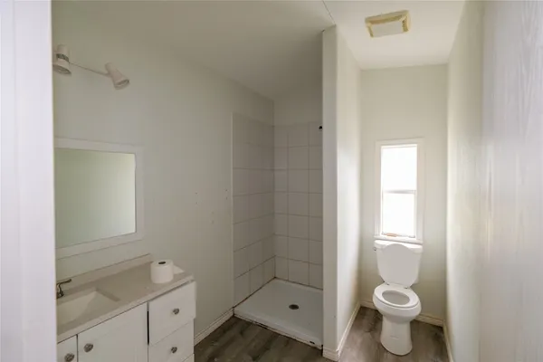 a bathroom with a granite countertop toilet a sink and a mirror