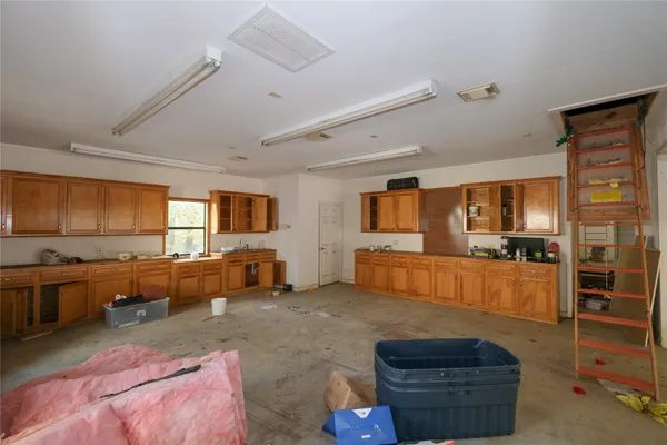 a living room with furniture kitchen view and a large window