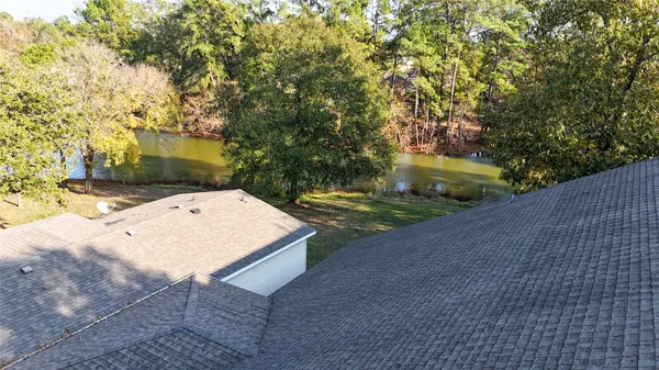an aerial view of residential building with outdoor space and trees all around