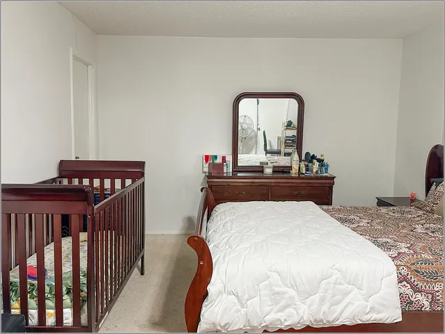 a bedroom with bed and wooden floor