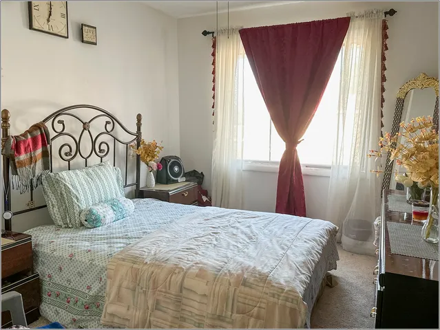 a bedroom with a bed next to a window