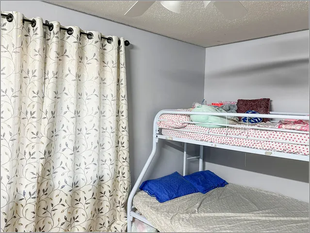 a bed sitting in a bedroom next to a window with wooden floor