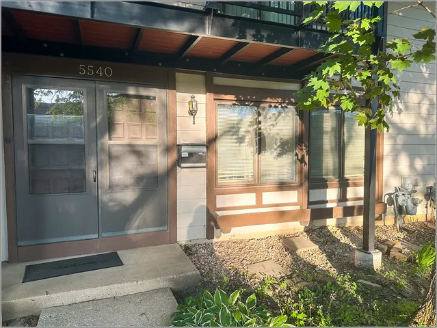a glass door with a tree in front of it