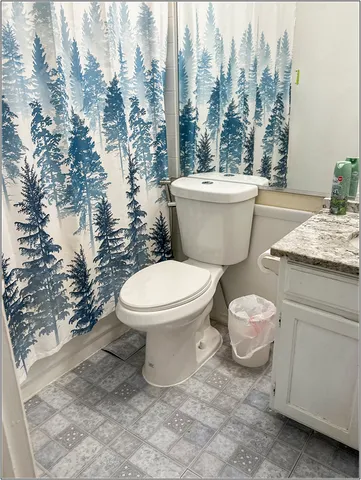 a white toilet sitting next to a bathroom sink