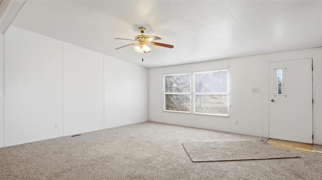 10902 County Road 414 Merkel, TX 79536 - Photo 11 of 26 an empty room with windows and chandelier fan