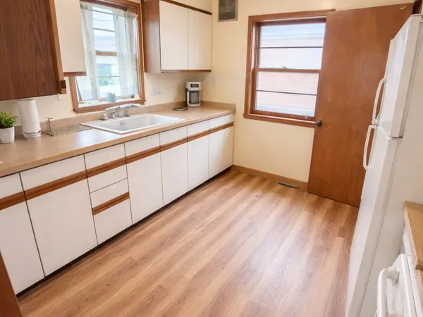a view of a kitchen with wooden floor and a sink