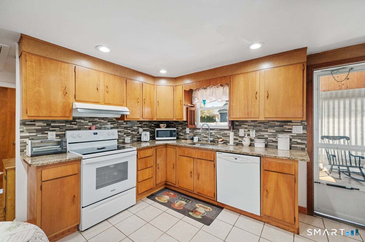 21 Brookside Circle Wethersfield, CT 06109 - Photo 16 of 39 a kitchen with stainless steel appliances granite countertop a stove a sink and white cabinets