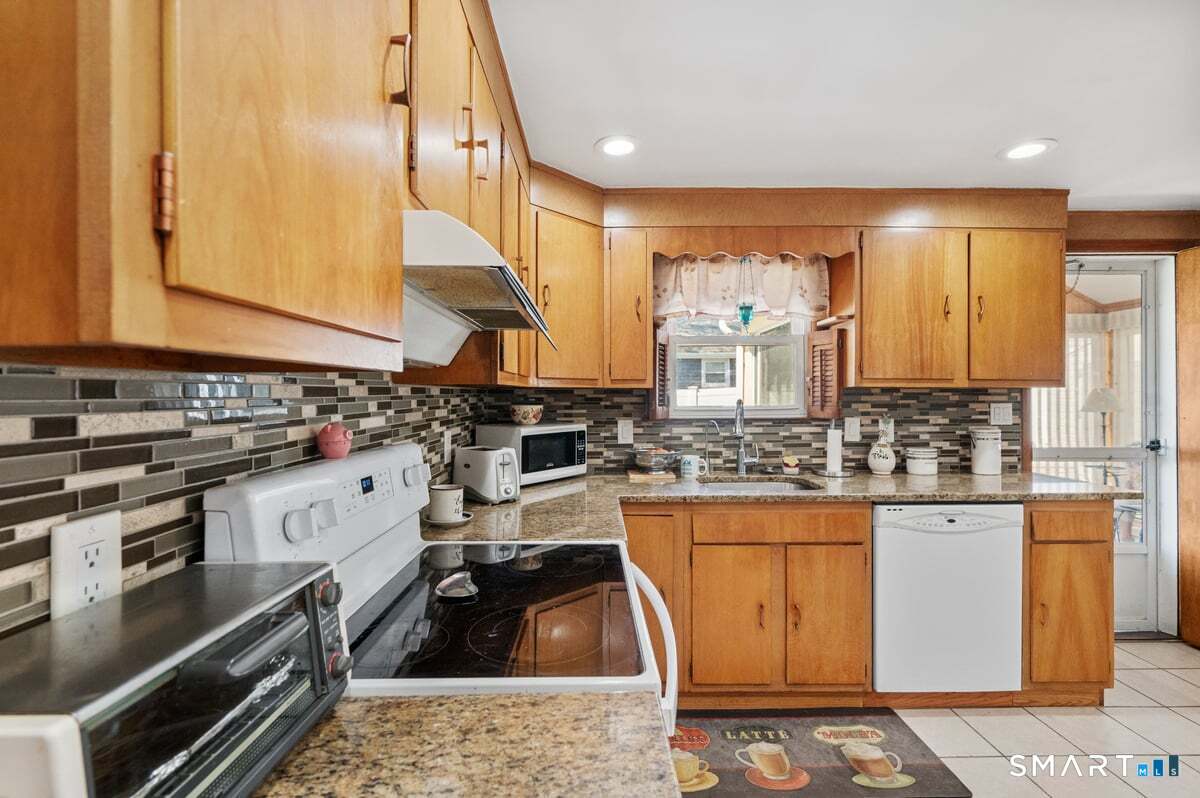 21 Brookside Circle Wethersfield, CT 06109 - Photo 18 of 39 a kitchen with granite countertop a stove a sink and a microwave