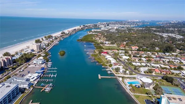 an aerial view of ocean and residential houses with outdoor space