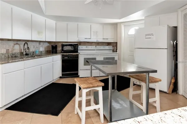 a kitchen with stainless steel appliances kitchen island granite countertop a stove a sink and a refrigerator