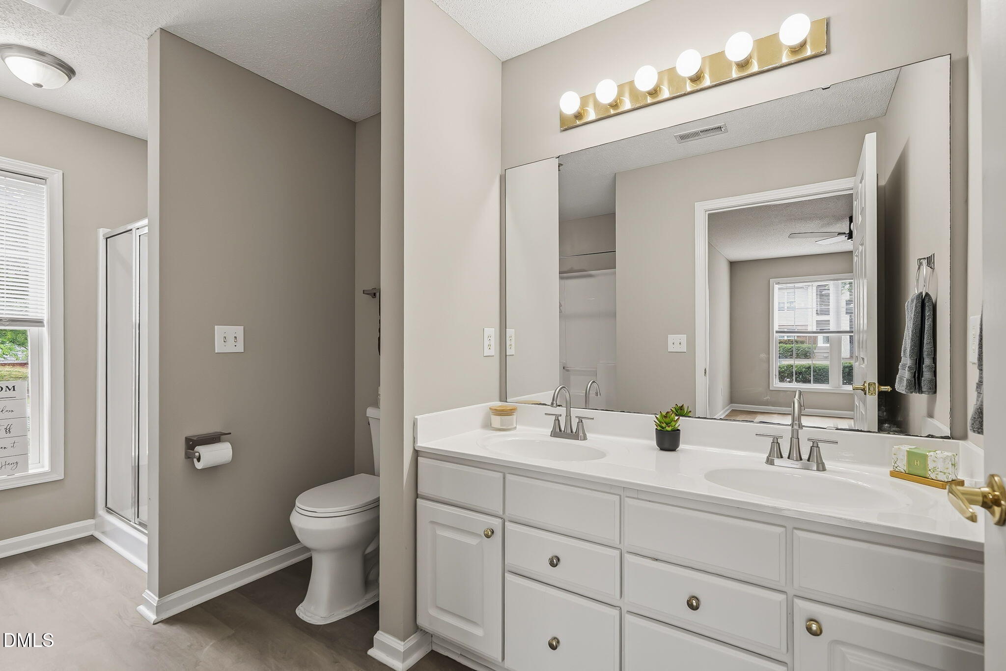 2501 Huntscroft Lane, Unit 100 Raleigh, NC 27617 - Photo 26 of 31 a bathroom with double vanity sink a toilet and a mirror