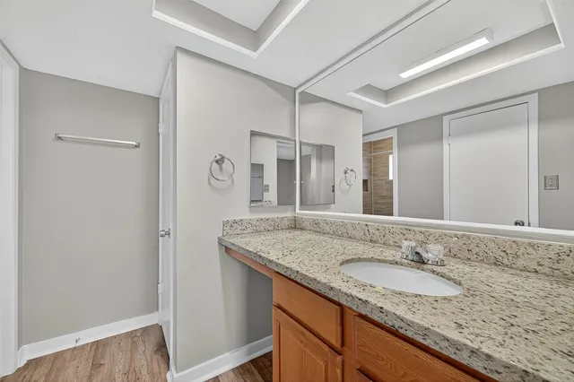 a bathroom with a granite countertop sink and a mirror