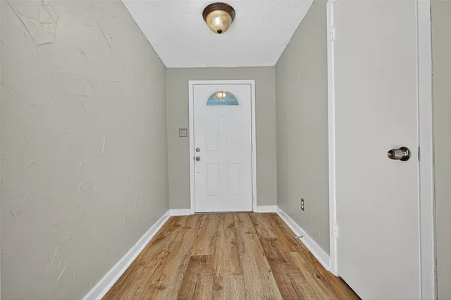 a view of a livingroom with wooden floor and a hallway