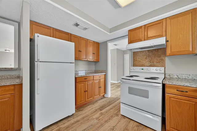 a kitchen with a refrigerator sink stove and cabinets