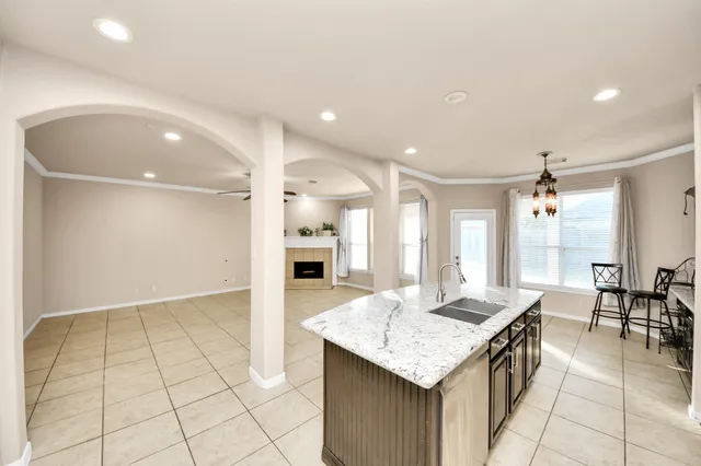 a kitchen with granite countertop a sink and a refrigerator
