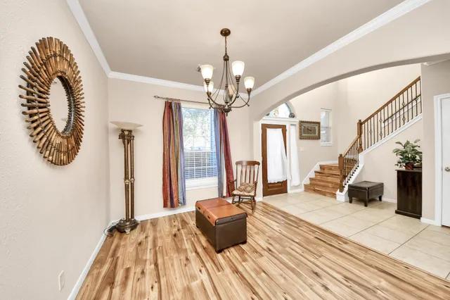a view of a livingroom with a fireplace a chandelier and wooden floor