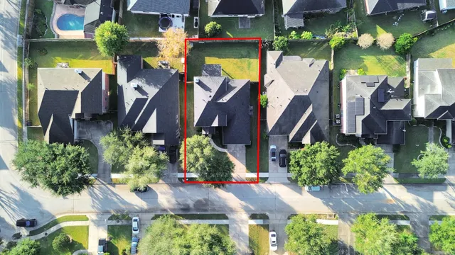 a view of a house with large trees and plants