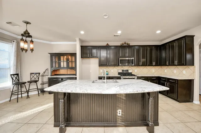 a kitchen with a stove a refrigerator and a dining table