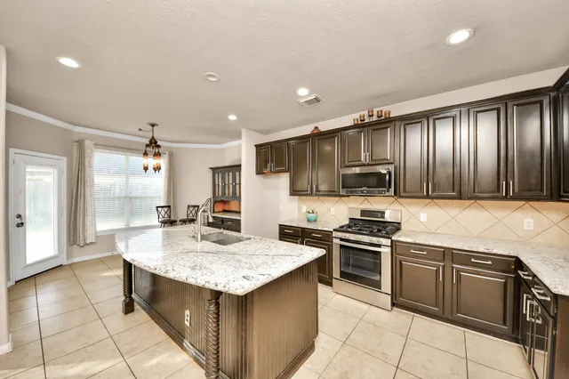a kitchen with a stove sink and cabinets