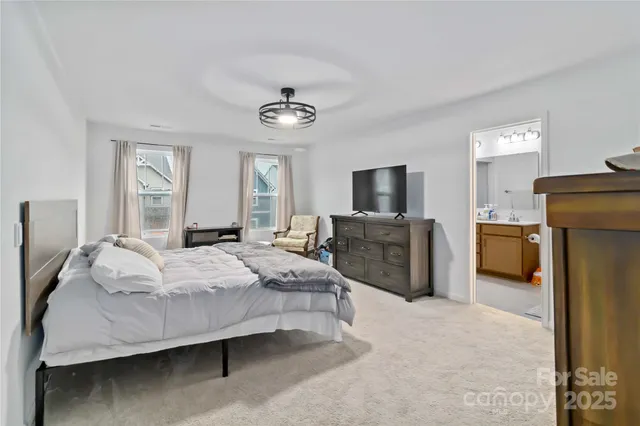 a spacious bedroom with a bed and a chandelier