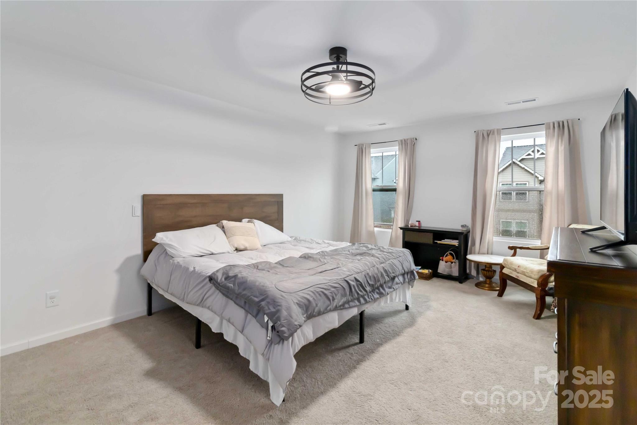 684 Candela Court York, SC 29745 - Photo 21 of 28 a spacious bedroom with a bed and a chandelier