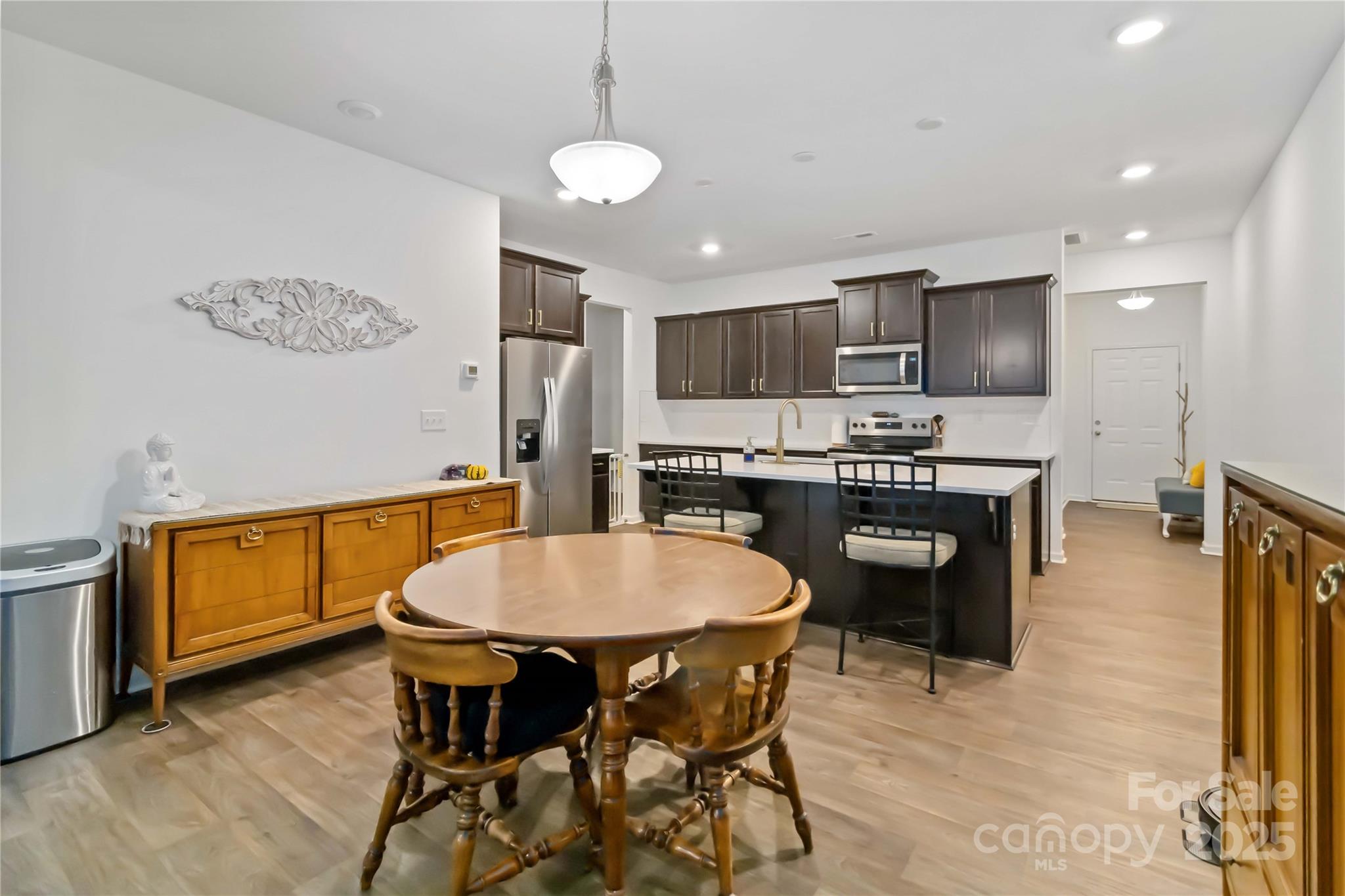 684 Candela Court York, SC 29745 - Photo 9 of 28 a kitchen with stainless steel appliances a dining table chairs and stove top oven