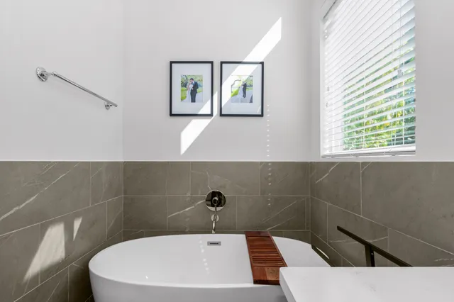 a bathroom with a sink a toilet a window and mirror