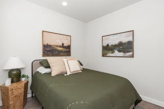 a bed sitting in a bedroom next to a wall paintings