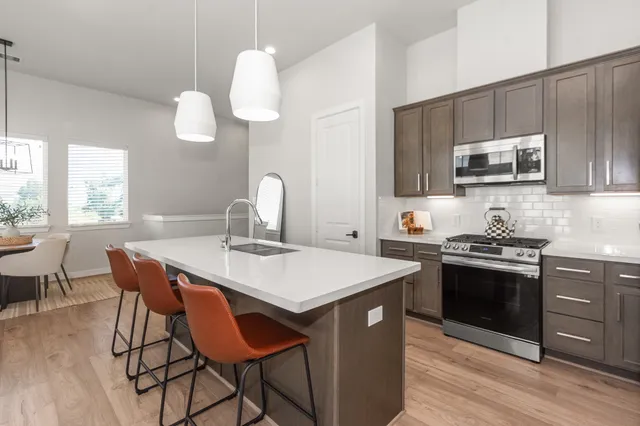 a kitchen with a stove a sink and a microwave