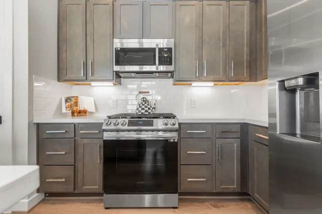 a kitchen with stainless steel appliances granite countertop a stove and a microwave