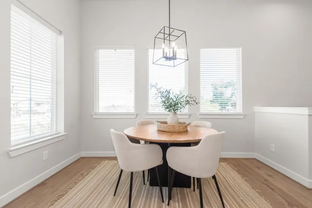 a dining room with furniture a chandelier and wooden floor
