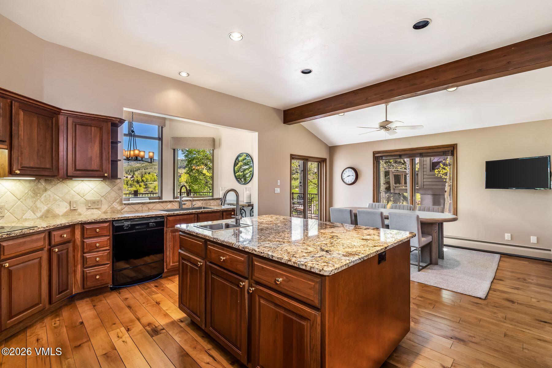 167 Saddle Ridge Edwards, CO 81632 - Photo 13 of 41 a large kitchen with granite countertop a sink and dishwasher wooden cabinets with granite countertops