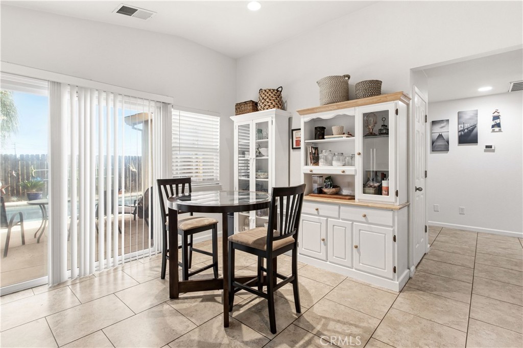 1478 La Sierra Street Merced, CA 95348 - Photo 11 of 32 a kitchen with stainless steel appliances kitchen island granite countertop a table and chairs in it
