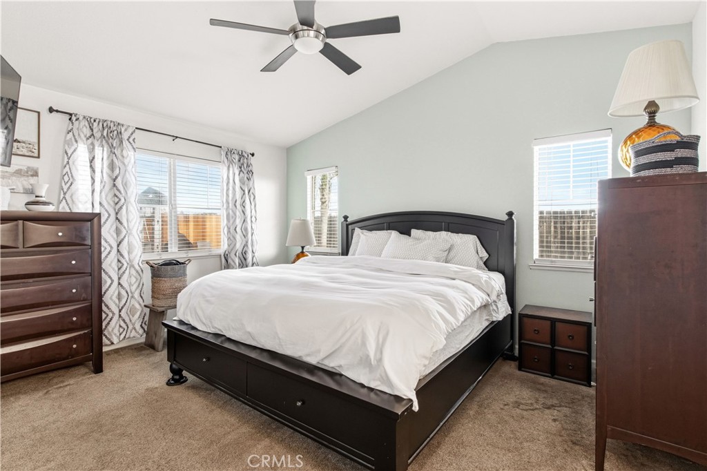 1478 La Sierra Street Merced, CA 95348 - Photo 16 of 32 a large bed sitting in a bedroom next to a window and a chandelier