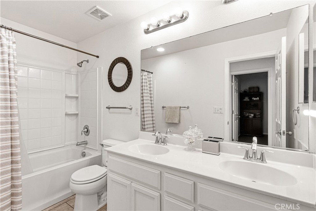 1478 La Sierra Street Merced, CA 95348 - Photo 24 of 32 a bathroom with a granite countertop sink a toilet a mirror and shower