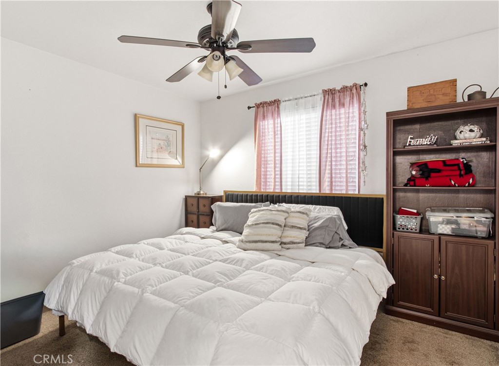 1478 La Sierra Street Merced, CA 95348 - Photo 27 of 32 a bedroom with a bed and a chandelier