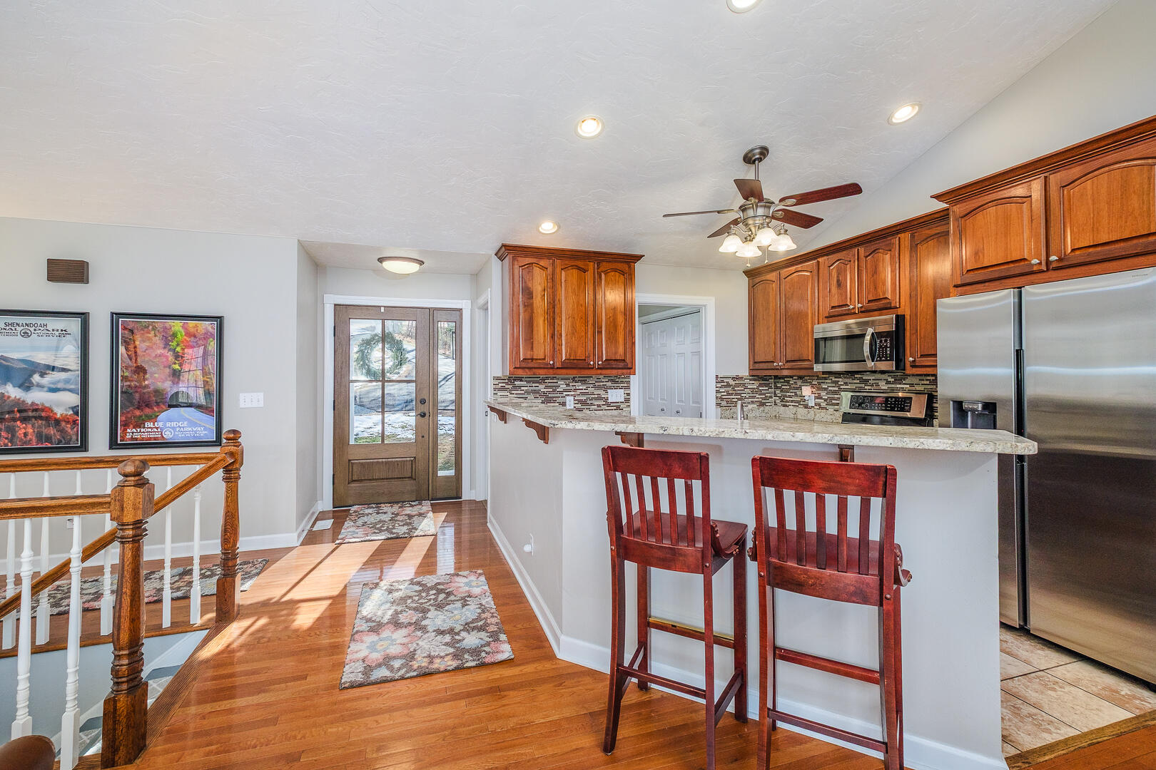 2085 Lakewood Forest Road Moneta, VA 24121 - Photo 7 of 76 a kitchen with stainless steel appliances granite countertop a refrigerator a stove top oven and a dining table with wooden floor