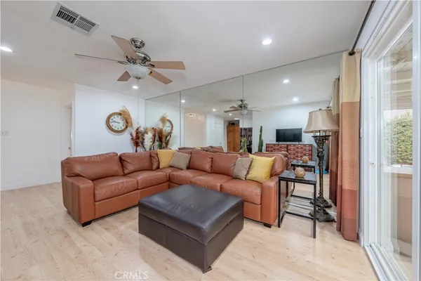 a living room with furniture kitchen area and a window