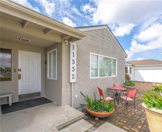 a view of a patio with table and chairs potted plants