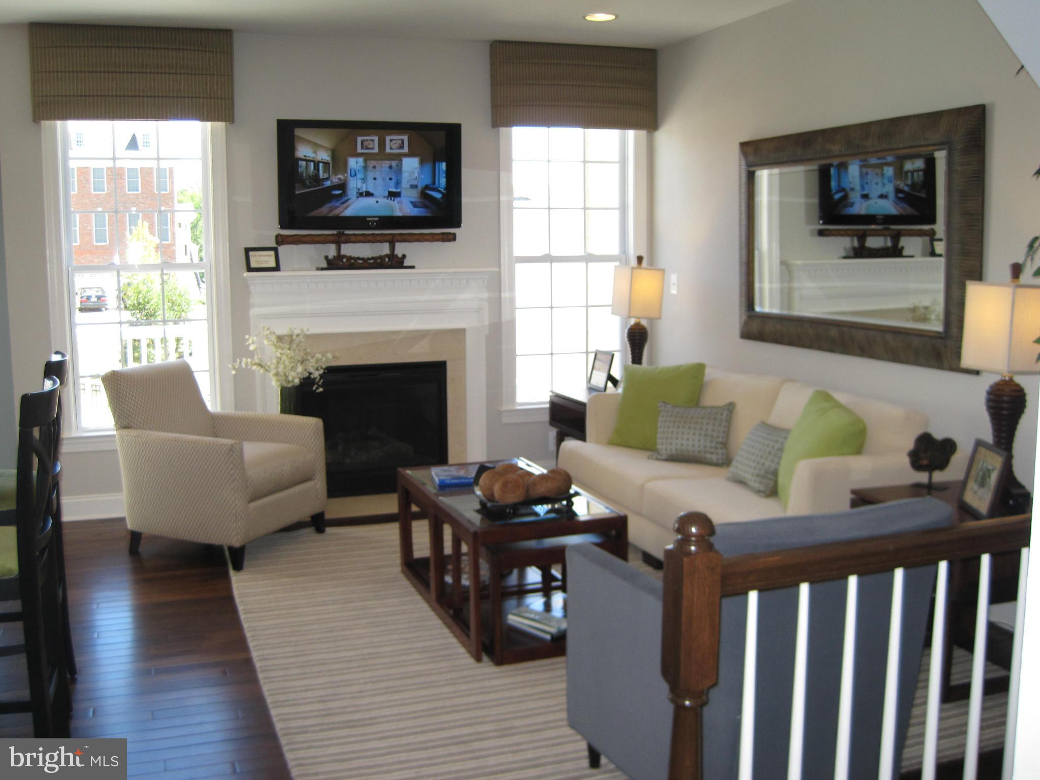 7683 Elmcrest Road Hanover, MD 21076 - Photo 2 of 13 a living room with furniture a flat screen tv and a fireplace