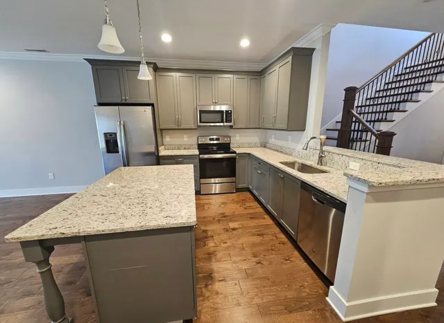a kitchen with kitchen island a sink stainless steel appliances and cabinets